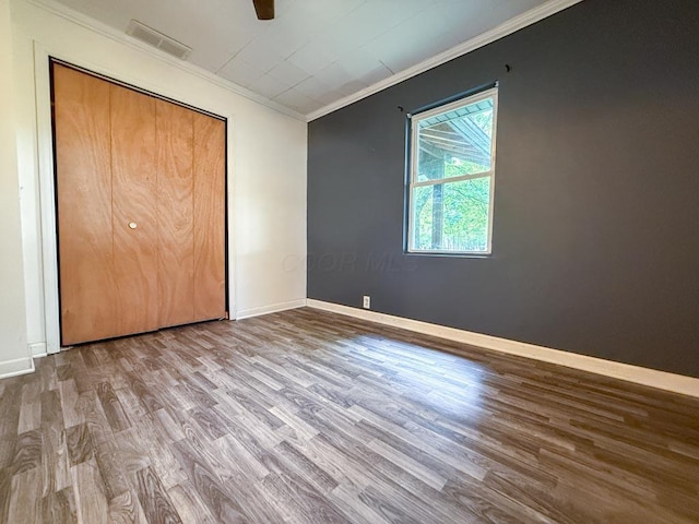206 William St, Fulton, OH 43321 - unfurnished bedroom featuring wood finished floors, ornamental molding, ceiling fan, and a closet