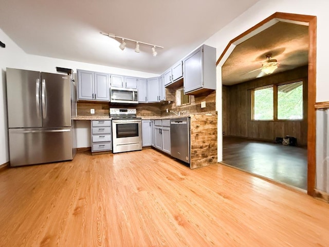 206 William St, Fulton, OH 43321 - kitchen featuring stainless steel appliances, gray cabinetry, light wood-style floors, and rail lighting