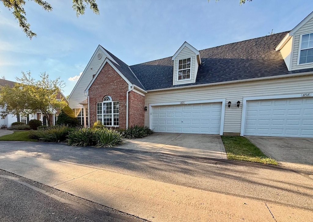 8699 Lazelle Commons Dr, Lewis Center, OH 43035 - view of front of house with concrete driveway, a garage, brick siding, and a shingled roof