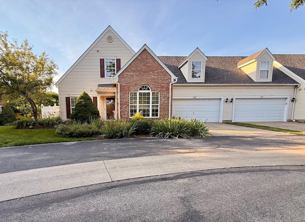 8699 Lazelle Commons Dr, Lewis Center, OH 43035 - view of front of house featuring concrete driveway, a garage, roof with shingles, and brick siding