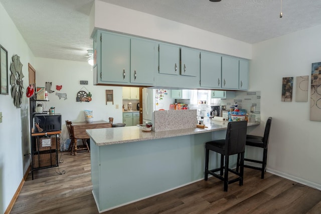 3709 Juniper St, Grove City, OH 43123 - kitchen featuring freestanding refrigerator, a peninsula, a textured ceiling, dark wood-type flooring, and blue cabinetry