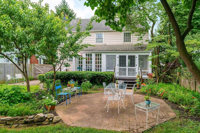1010 Vernon Rd, Columbus, OH 43209 - rear view of house featuring a sunroom, a patio area, a fenced backyard, and roof with shingles