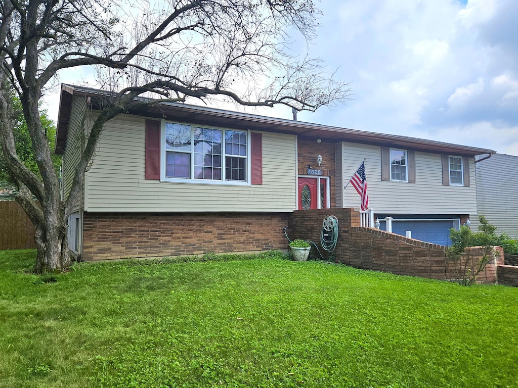 1328 Hilton Dr, Reynoldsburg, OH 43068 - bi-level home with brick siding, an attached garage, and a front yard
