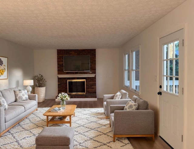 5078 Grassland Dr, Dublin, OH 43016 - living room with wood finished floors, a textured ceiling, and a brick fireplace