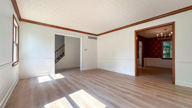 5078 Grassland Dr, Dublin, OH 43016 - spare room with light wood-style floors, stairs, a chandelier, a textured ceiling, and ornamental molding