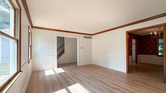 5078 Grassland Dr, Dublin, OH 43016 - spare room featuring light wood-type flooring, stairway, a chandelier, a textured ceiling, and ornamental molding