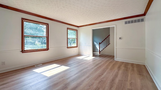 5078 Grassland Dr, Dublin, OH 43016 - spare room featuring light wood-style flooring, a textured ceiling, crown molding, and stairs