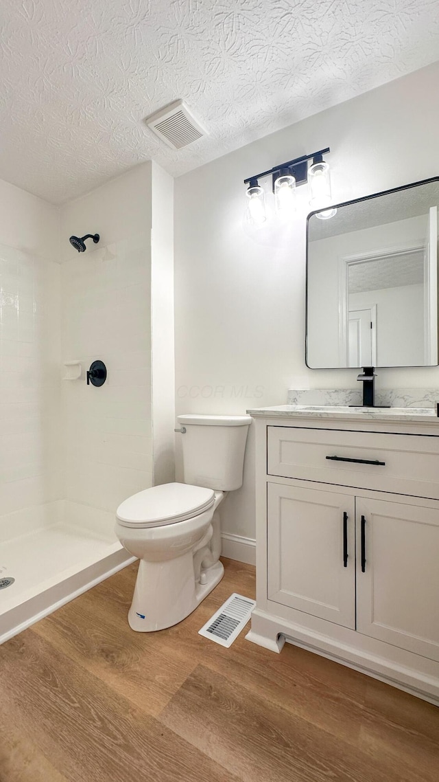5078 Grassland Dr, Dublin, OH 43016 - full bath with vanity, wood finished floors, a shower, and a textured ceiling