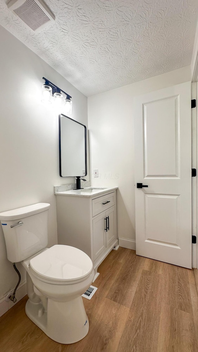 5078 Grassland Dr, Dublin, OH 43016 - bathroom featuring wood finished floors, a textured ceiling, and vanity