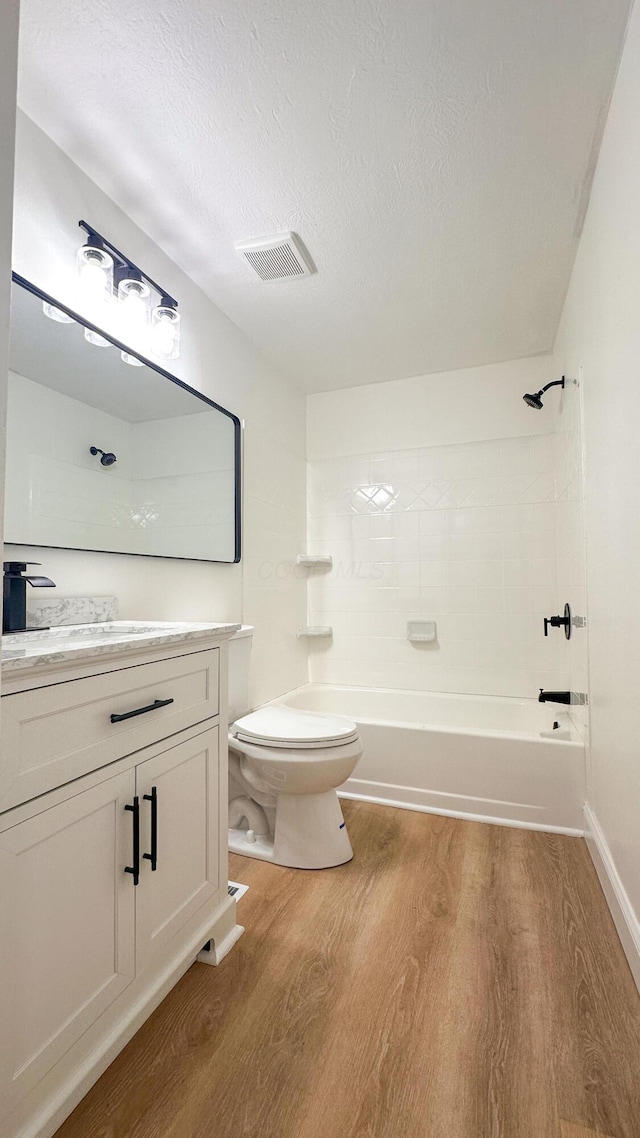 5078 Grassland Dr, Dublin, OH 43016 - bathroom featuring wood finished floors, vanity, shower / washtub combination, and a textured ceiling