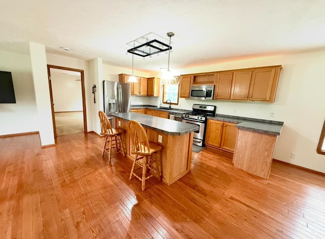 13944 Lafayette Rd, Utica, OH 43080 - kitchen featuring stainless steel appliances, dark countertops, hardwood / wood-style flooring, and a kitchen bar