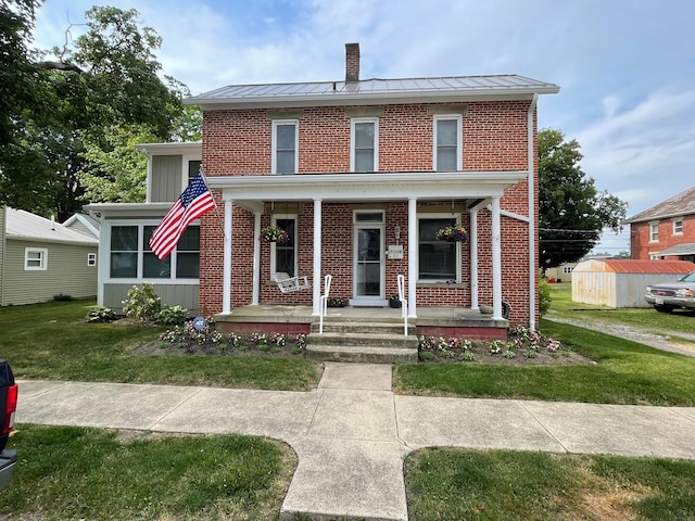 61 Church St, Ashville, OH 43103 - view of front of home featuring a standing seam roof, brick siding, a front yard, a chimney, and a metal roof
