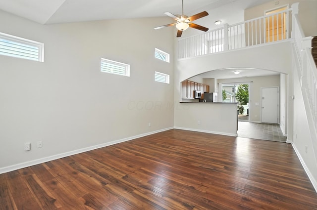5804 Trail Creek Dr, Dublin, OH 43016 - unfurnished living room featuring a ceiling fan, dark wood-type flooring, arched walkways, and a towering ceiling