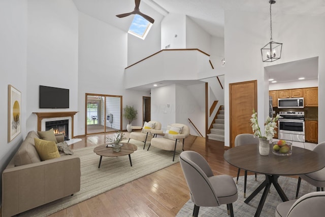 1280 Gemstone Sq W, Westerville, OH 43081 - living room featuring stairway, high vaulted ceiling, a lit fireplace, light wood finished floors, and ceiling fan