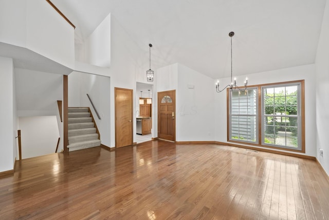 1280 Gemstone Sq W, Westerville, OH 43081 - unfurnished living room with a chandelier, hardwood / wood-style flooring, high vaulted ceiling, and stairs