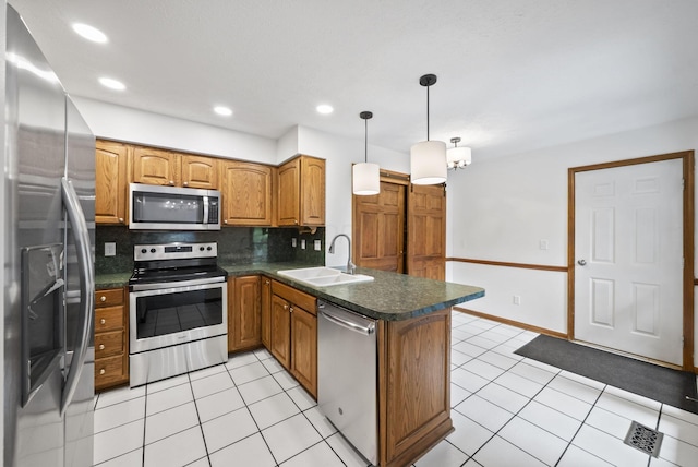 1280 Gemstone Sq W, Westerville, OH 43081 - kitchen featuring a peninsula, appliances with stainless steel finishes, brown cabinets, dark countertops, and backsplash