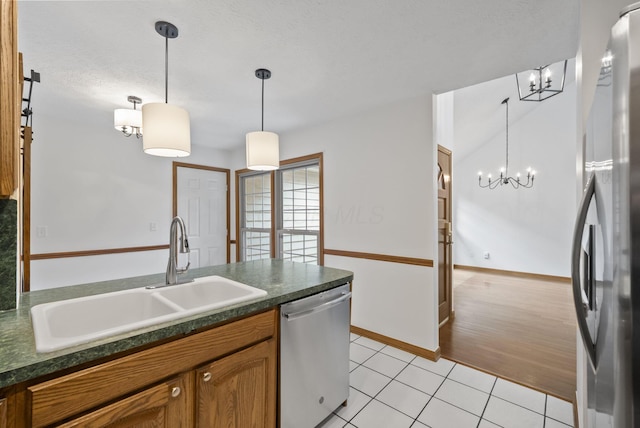 1280 Gemstone Sq W, Westerville, OH 43081 - kitchen with a chandelier, dark countertops, stainless steel appliances, brown cabinetry, and light tile patterned flooring