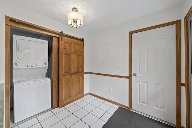 1280 Gemstone Sq W, Westerville, OH 43081 - laundry area with stacked washer / dryer, a barn door, and light tile patterned floors