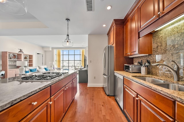 1475 W 3rd Ave Unit 401, Columbus, OH 43212 - kitchen with tasteful backsplash, appliances with stainless steel finishes, recessed lighting, light wood-style floors, and light stone countertops
