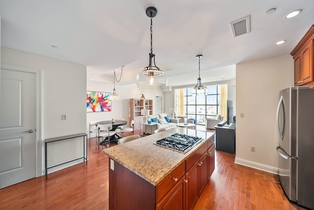 1475 W 3rd Ave Unit 401, Columbus, OH 43212 - kitchen featuring stainless steel appliances, light wood-type flooring, a center island, brown cabinets, and recessed lighting