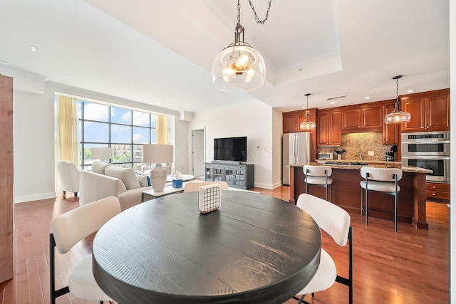 1475 W 3rd Ave Unit 401, Columbus, OH 43212 - dining room featuring light wood-style flooring, crown molding, and a tray ceiling
