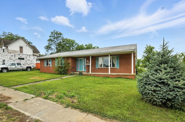 24 W High St, Jeffersonville, OH 43128 - view of front of home with a front lawn, brick siding, and covered porch