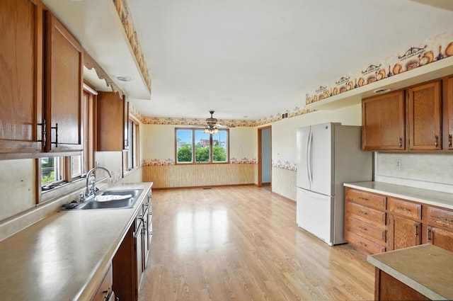 24 W High St, Jeffersonville, OH 43128 - kitchen featuring light wood finished floors, a ceiling fan, brown cabinetry, light countertops, and freestanding refrigerator