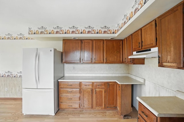 24 W High St, Jeffersonville, OH 43128 - kitchen featuring freestanding refrigerator, brown cabinets, light wood-type flooring, and light countertops