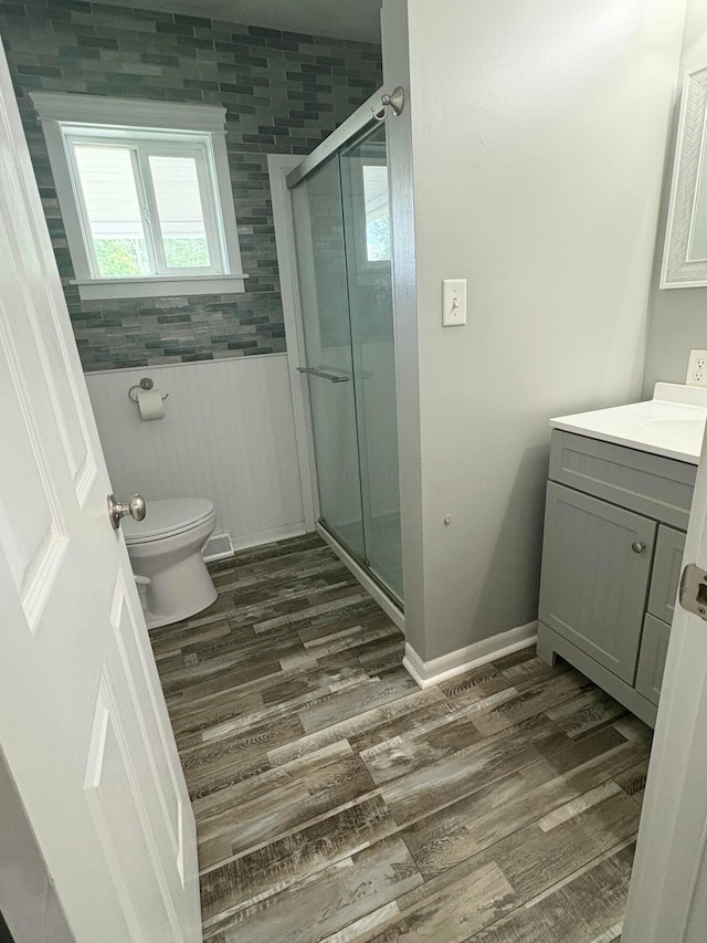 5356 Harding Hwy E, Caledonia, OH 43314 - full bathroom with vanity, a shower stall, wood finished floors, and a wainscoted wall