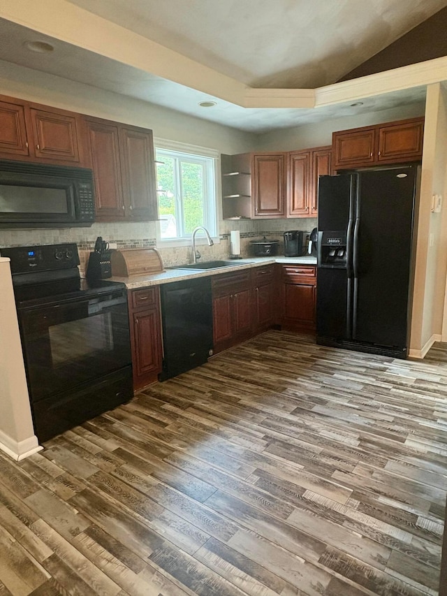 5356 Harding Hwy E, Caledonia, OH 43314 - kitchen with black appliances, dark wood finished floors, light countertops, decorative backsplash, and vaulted ceiling