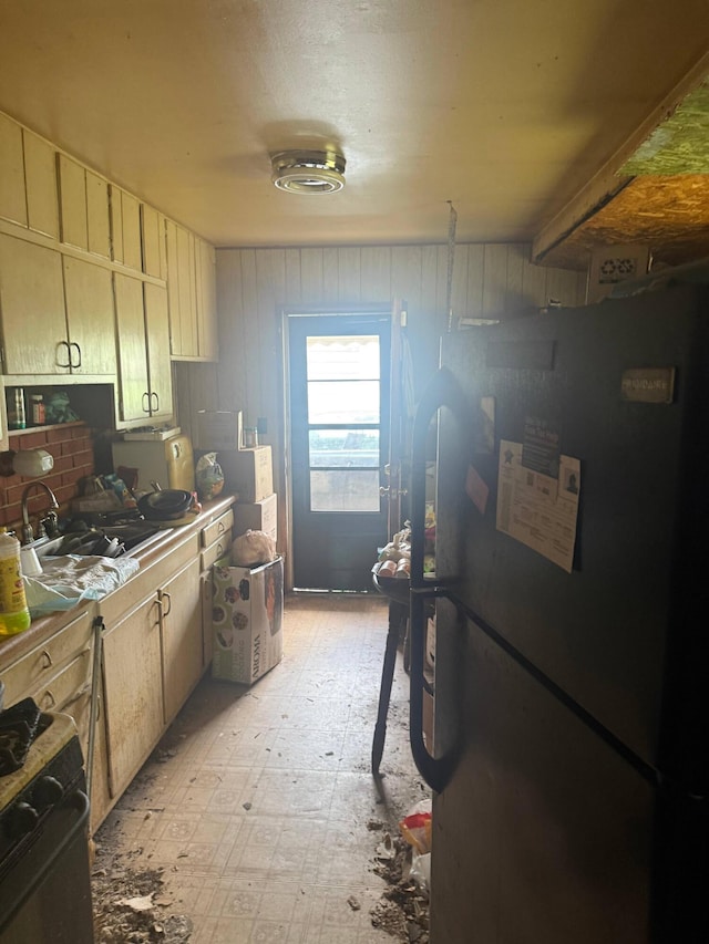 3032 Baker Hill Rd, Columbus, OH 43207 - kitchen featuring black appliances, light floors, and wood walls