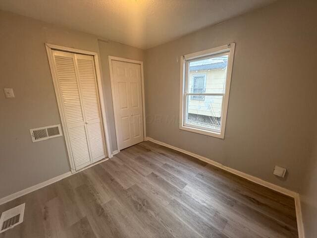 unfurnished bedroom featuring baseboards and wood finished floors
