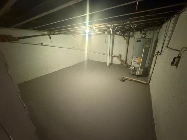 unfinished basement featuring water heater