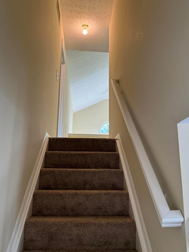 6282 Mcnaughten Place Ln Unit 39, Columbus, OH 43213 - staircase with vaulted ceiling and a textured ceiling