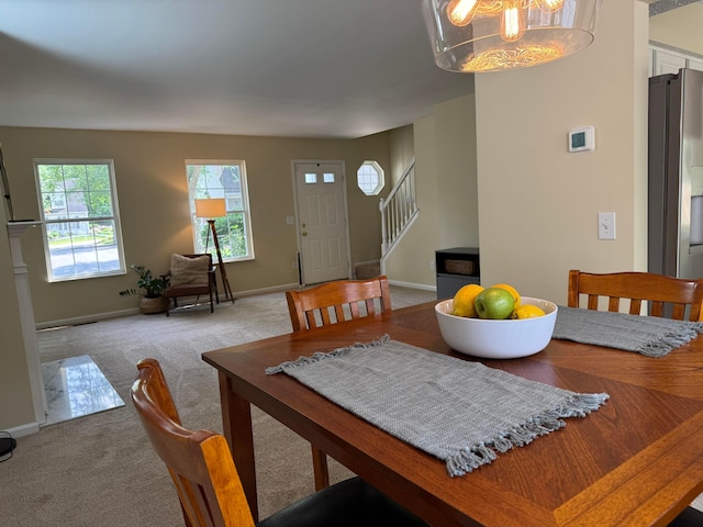 6282 Mcnaughten Place Ln Unit 39, Columbus, OH 43213 - dining room with healthy amount of natural light, stairway, light carpet, and a chandelier