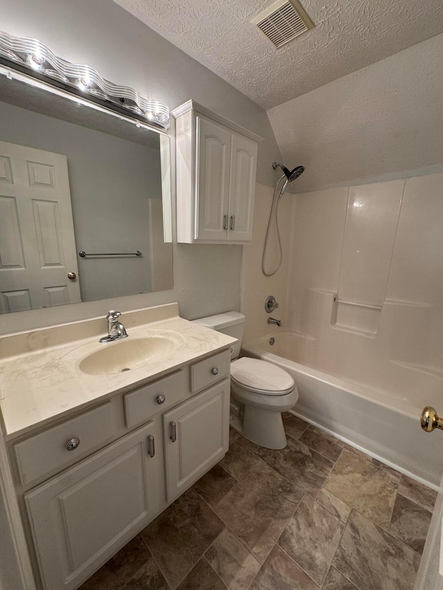 6282 Mcnaughten Place Ln Unit 39, Columbus, OH 43213 - full bathroom featuring a textured ceiling, vanity, vaulted ceiling, washtub / shower combination, and stone finish flooring