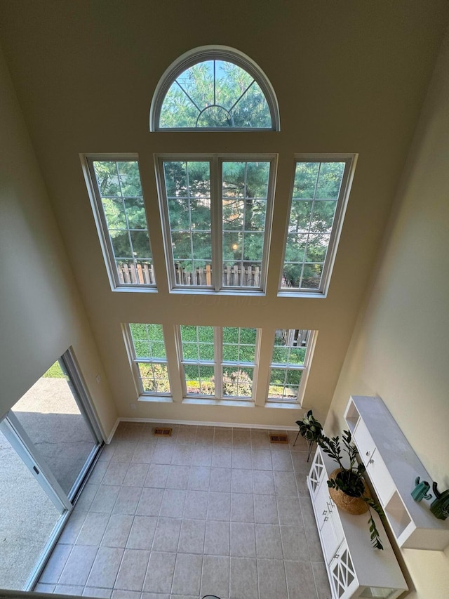 6282 Mcnaughten Place Ln Unit 39, Columbus, OH 43213 - unfurnished living room with a towering ceiling and light tile patterned floors