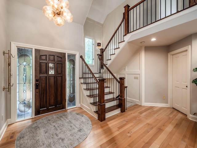 5767 Loch Maree Ct, Dublin, OH 43017 - foyer with a chandelier, light wood finished floors, high vaulted ceiling, and stairway