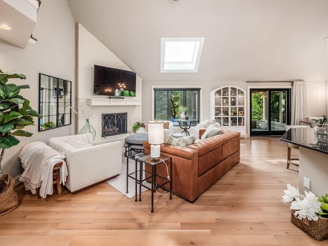 5767 Loch Maree Ct, Dublin, OH 43017 - living area featuring a skylight, high vaulted ceiling, a fireplace, and light wood-style flooring