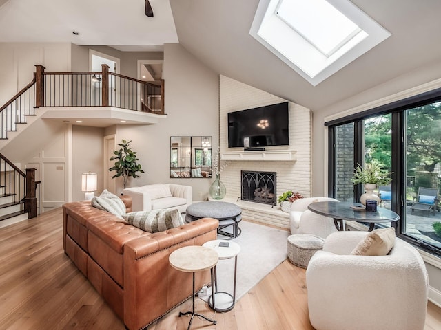 5767 Loch Maree Ct, Dublin, OH 43017 - living room with wood finished floors, stairs, a skylight, high vaulted ceiling, and a fireplace