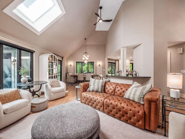 5767 Loch Maree Ct, Dublin, OH 43017 - living area with high vaulted ceiling, light wood-style flooring, a skylight, ceiling fan, and a chandelier
