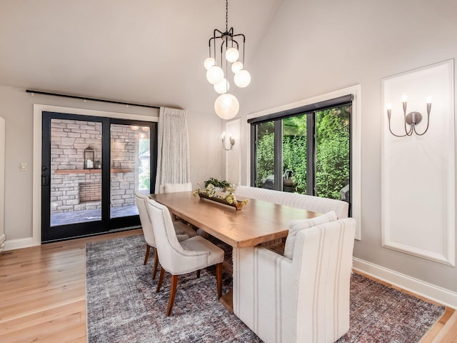 5767 Loch Maree Ct, Dublin, OH 43017 - dining room featuring healthy amount of natural light, light wood finished floors, a chandelier, and high vaulted ceiling