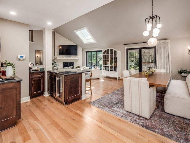 5767 Loch Maree Ct, Dublin, OH 43017 - kitchen with open floor plan, wine cooler, light wood-style flooring, lofted ceiling, and hanging light fixtures