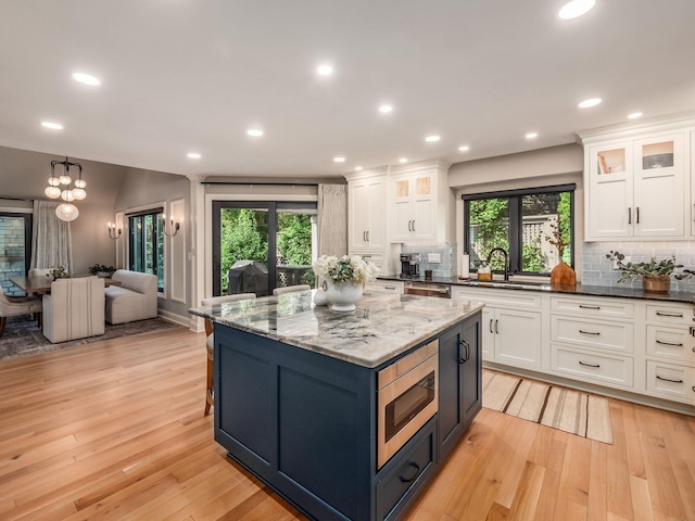 5767 Loch Maree Ct, Dublin, OH 43017 - kitchen with white cabinets, tasteful backsplash, light wood-style floors, and recessed lighting