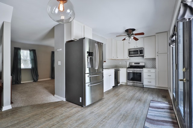 7617 Whitneyway Dr Unit 120, Columbus, OH 43085 - kitchen with stainless steel appliances, backsplash, white cabinets, a ceiling fan, and light wood finished floors