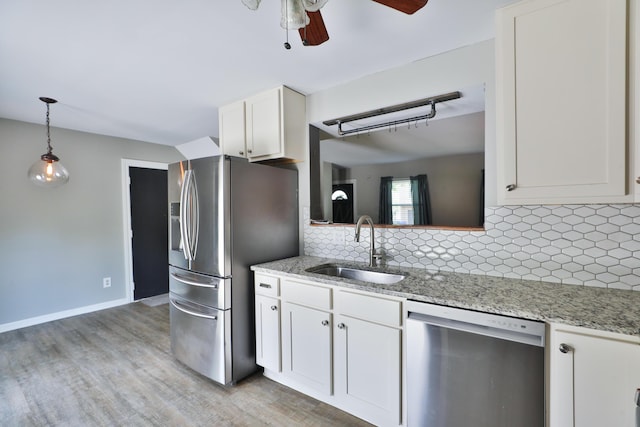 7617 Whitneyway Dr Unit 120, Columbus, OH 43085 - kitchen with appliances with stainless steel finishes, a ceiling fan, light wood finished floors, white cabinets, and tasteful backsplash