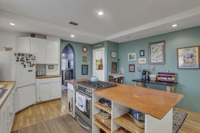 131 E Chestnut St, Lancaster, OH 43130 - kitchen featuring gas stove, freestanding refrigerator, white cabinets, arched walkways, and light wood-type flooring