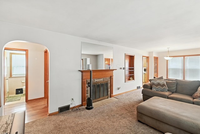 305 N Boston St, Galion, OH 44833 - living room with a fireplace with flush hearth, arched walkways, and wood finished floors