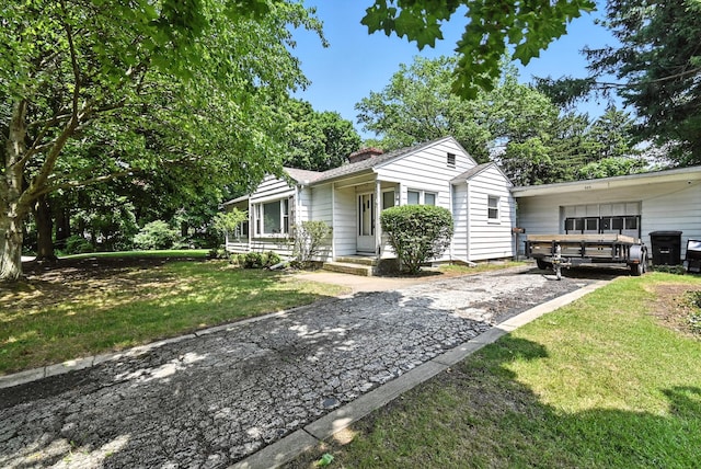 305 N Boston St, Galion, OH 44833 - view of front facade featuring driveway, a chimney, and a front yard