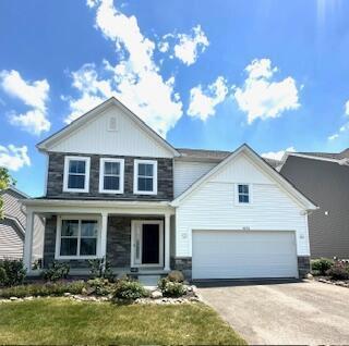 1073 Quarry Oak Dr, Grove City, OH 43123 - view of front of property with driveway, a front lawn, stone siding, and covered porch